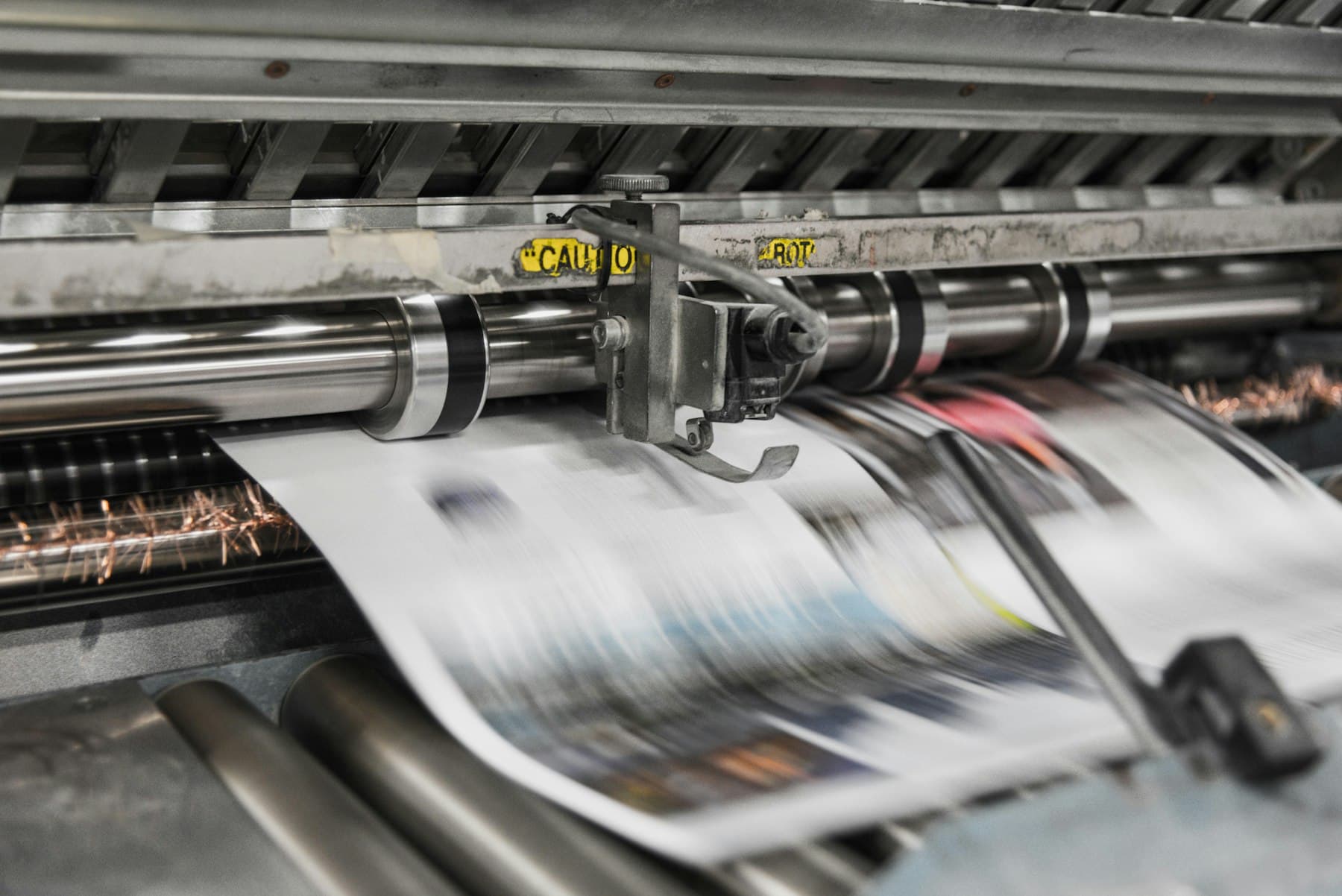 Sheets running through a commercial offset printing press at speed